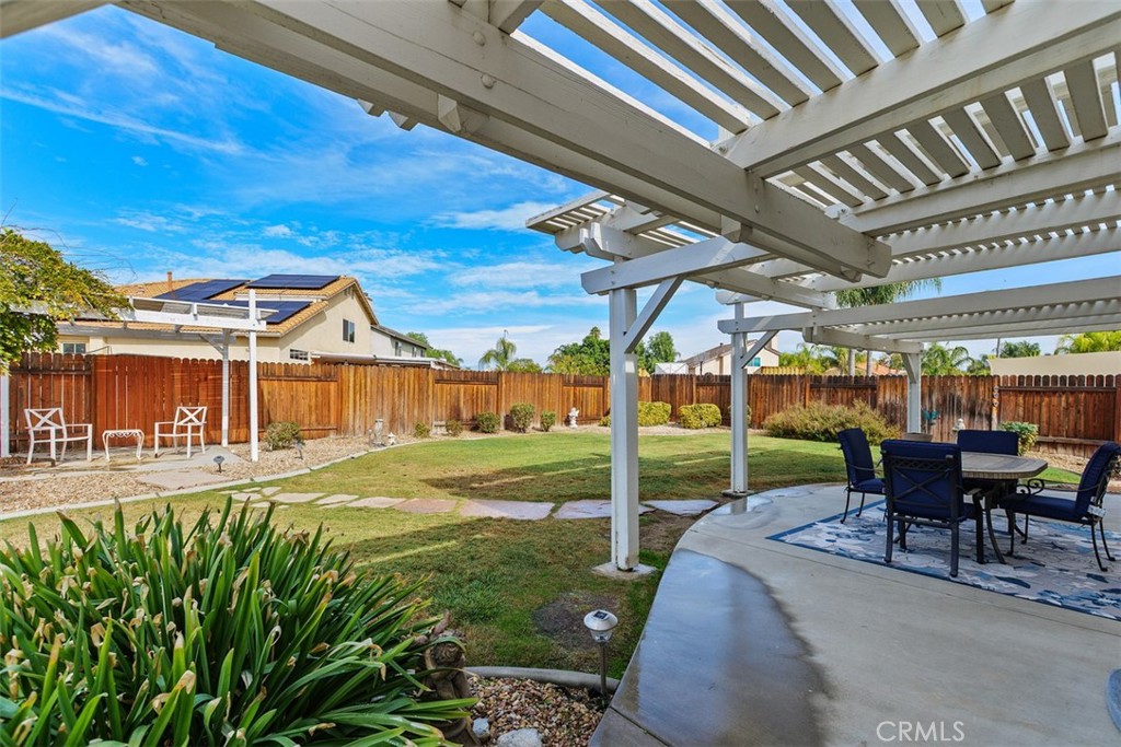 25644 Pelion Road Menifee, CA 92584 - Photo 23 of 26 a view of a patio with table and chairs potted plants with palm trees