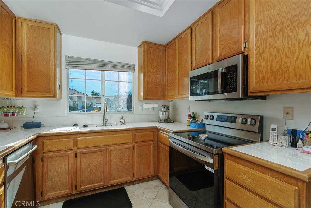 25644 Pelion Road Menifee, CA 92584 - Photo 10 of 26 a kitchen with stainless steel appliances granite countertop a sink stove and microwave