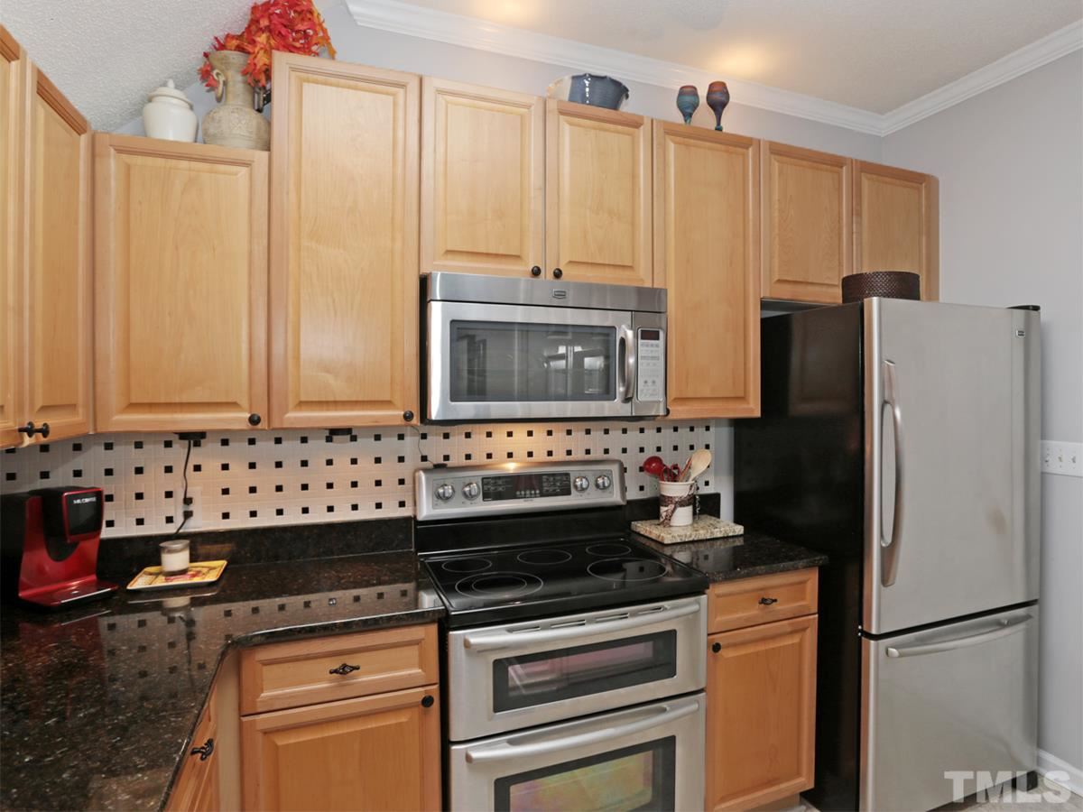 2025 Persimmon Ridge Drive Raleigh, NC 27604 - Photo 6 of 19 a kitchen with granite countertop a refrigerator stove and sink