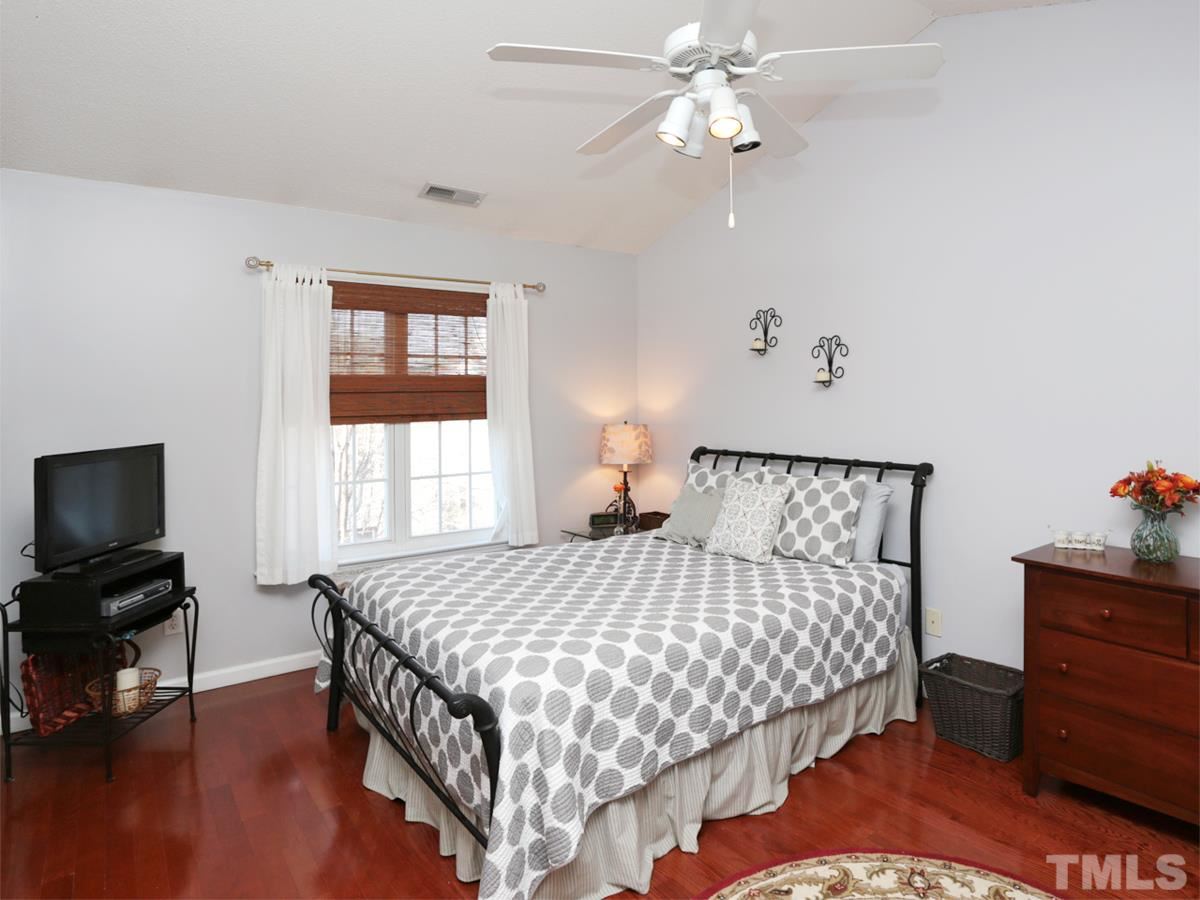 2025 Persimmon Ridge Drive Raleigh, NC 27604 - Photo 8 of 19 a bedroom with a bed and a chandelier
