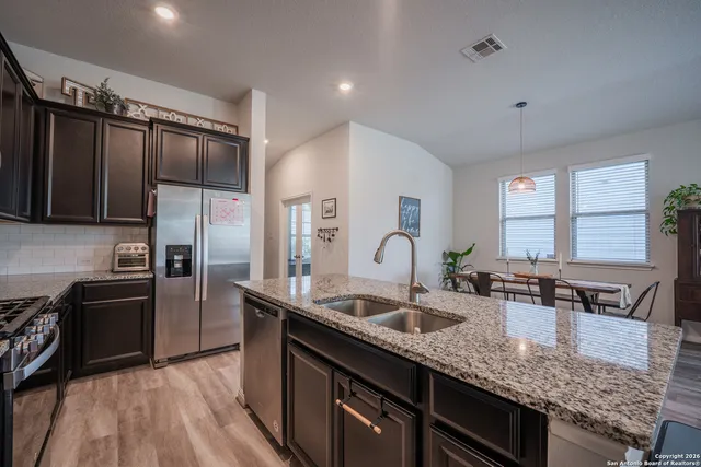 a kitchen with stainless steel appliances granite countertop a sink stove and refrigerator
