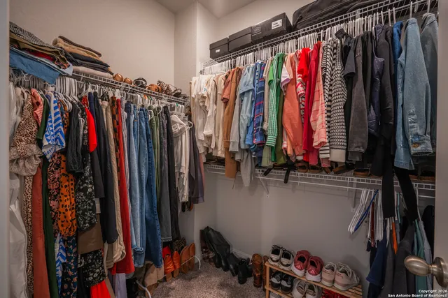 a view of walk in closet with clothes