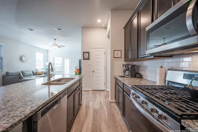 a kitchen with kitchen island granite countertop a sink stove and refrigerator