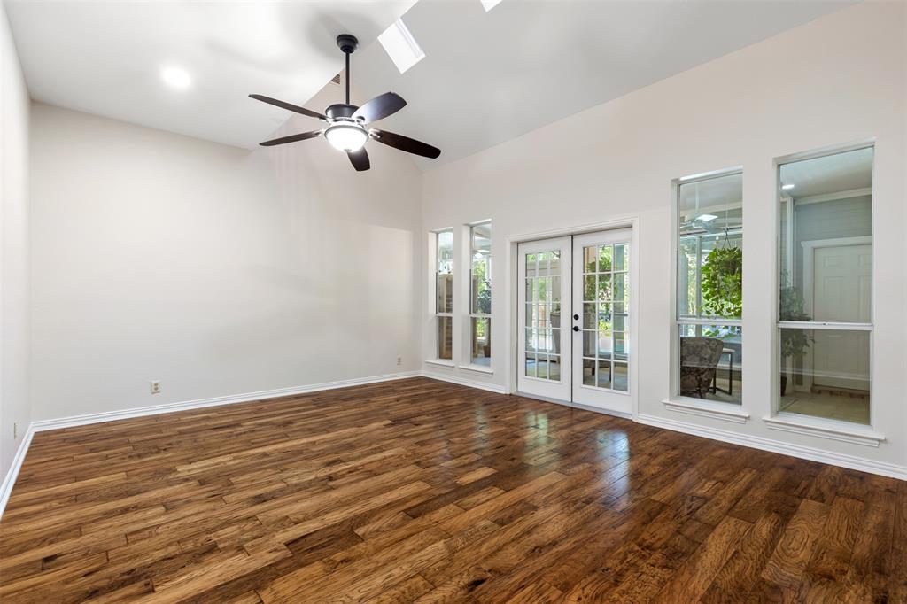 609 Seville Road Denton, TX 76205 - Photo 15 of 40 Living Room 4 with hardwood floors, ceiling fan, doors to sunroom.