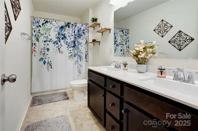 a spacious bathroom with a sink a toilet and shower curtain
