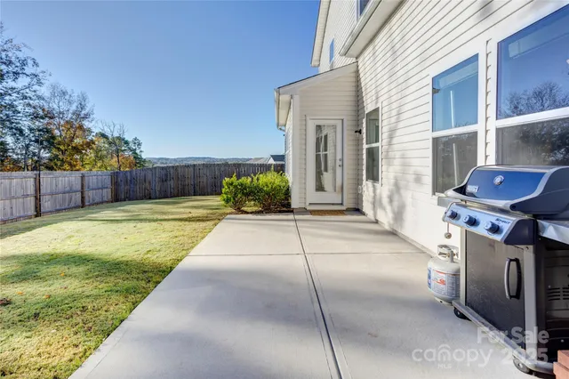 a view of a backyard with couches under an umbrella