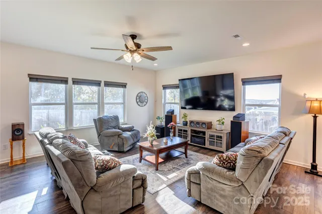 a living room with furniture flat screen tv and a large window