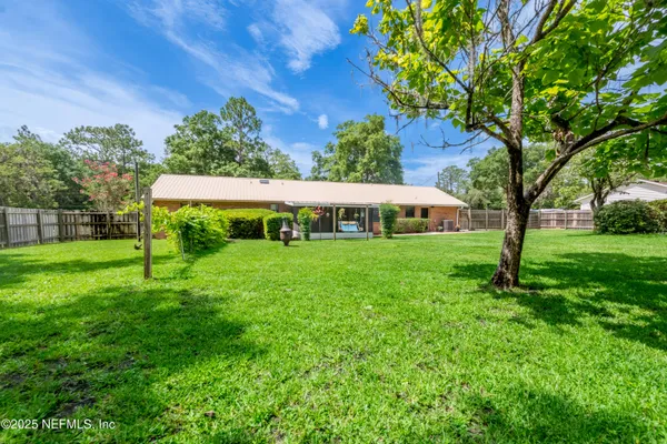 a backyard with table and chairs and potted plants