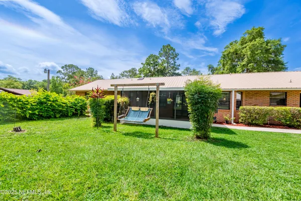 a backyard of a house with table and chairs