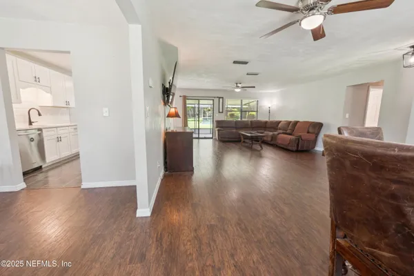 an empty room with wooden floor closet and windows