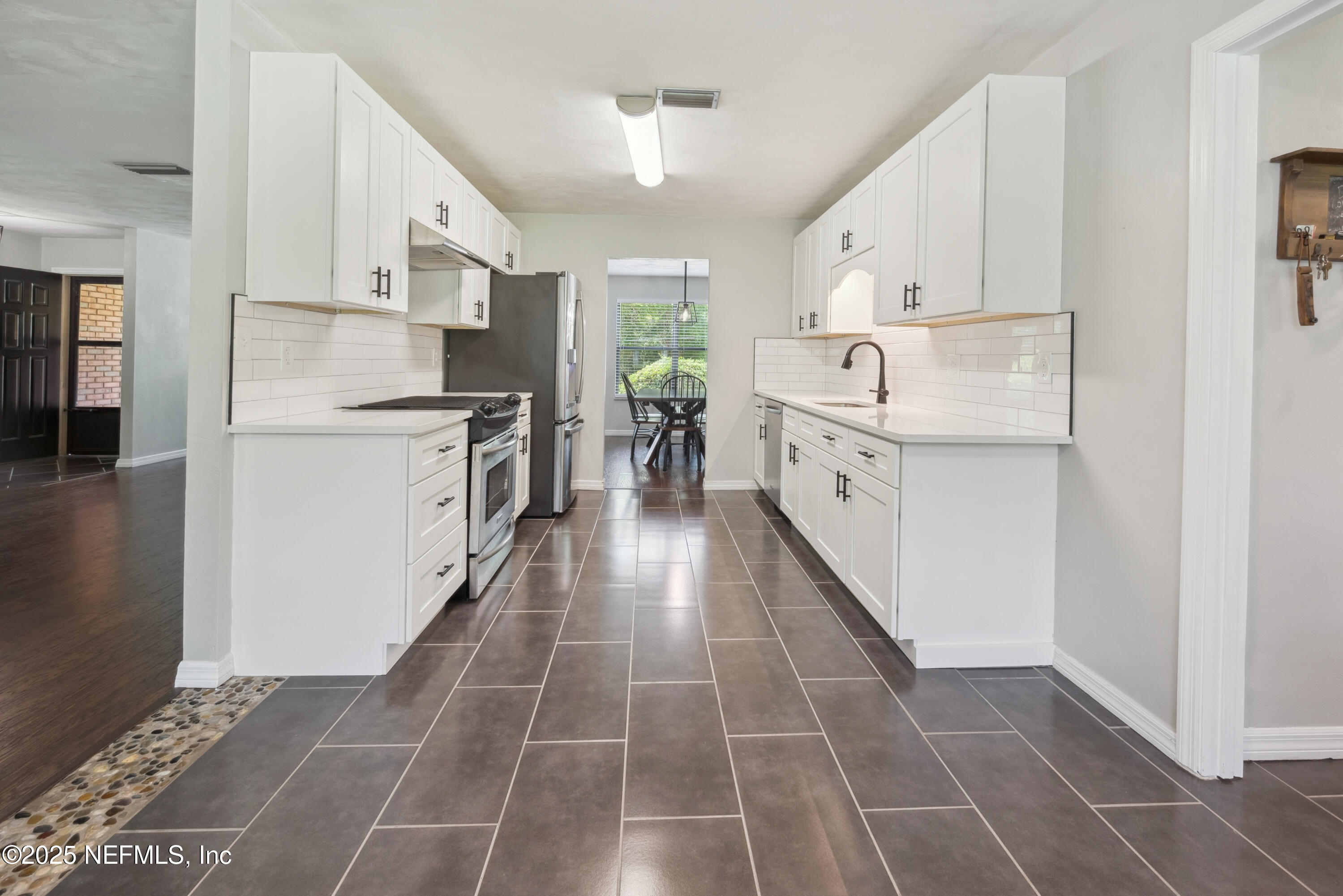 363 Southeast 73rd Street Starke, FL 32091 - Photo 35 of 49 a kitchen with a sink a stove top oven and white cabinets