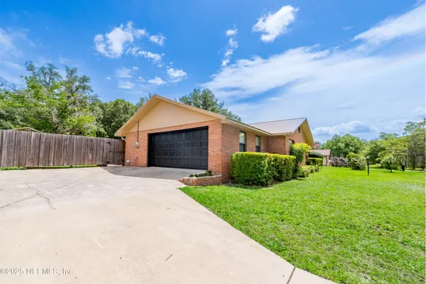 a aerial view of a house next to a yard
