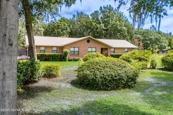 a view of an house with backyard space and balcony
