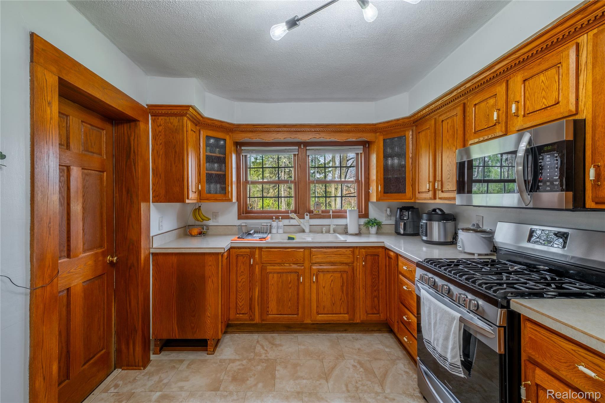 12164 Miller Road Lennon, MI 48449 - Photo 20 of 35 Kitchen with stainless steel appliances, light countertops, a textured ceiling, and wood finish cabinetry