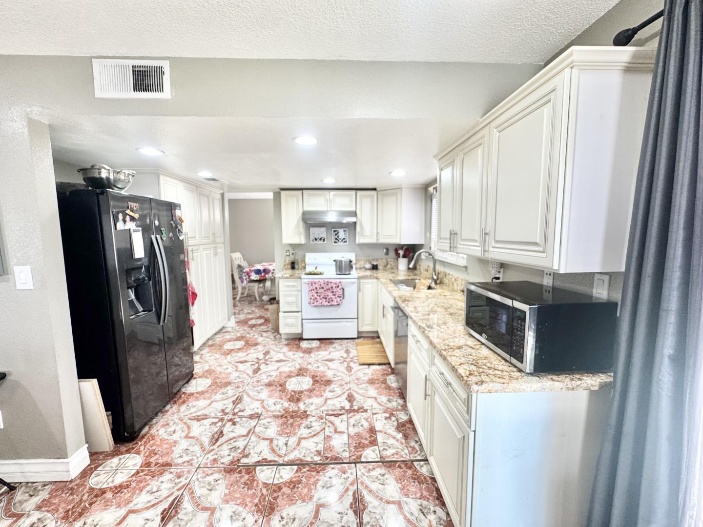 7605 Golden Rise Court Bakersfield, CA 93313 - Photo 6 of 16 a kitchen with stainless steel appliances granite countertop a refrigerator a stove top oven and a sink