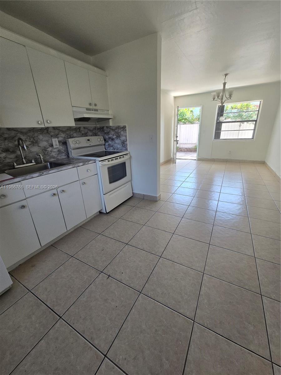 15 West 9th Street, Unit 3 Hialeah, FL 33010 - Photo 6 of 9 a kitchen with cabinets and window