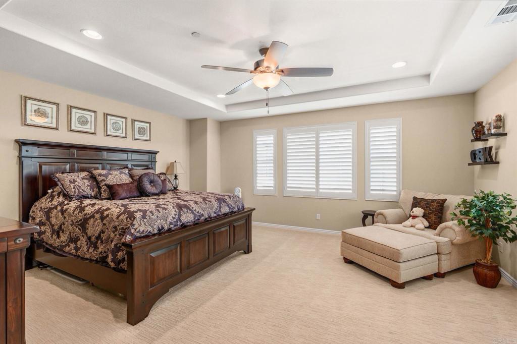 809 Dolphin Circle Encinitas, CA 92024 - Photo 36 of 71 a spacious bedroom with a bed and a chandelier