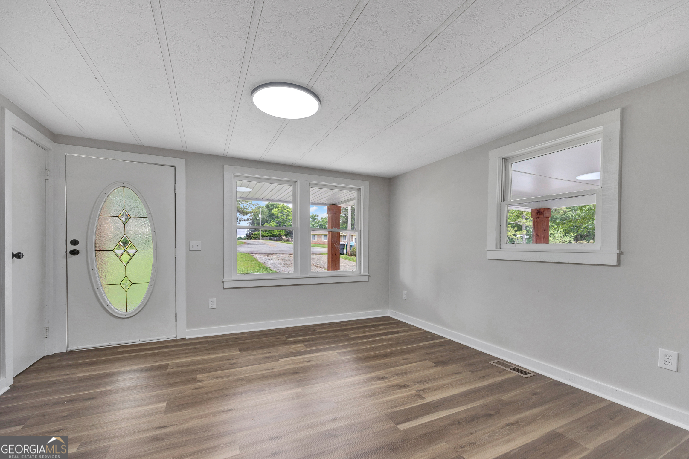 455 Cindy Street Jackson, GA 30233 - Photo 3 of 25 an empty room with window and wooden floor
