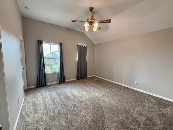 a view of an empty room with a chandelier fan