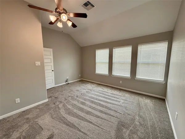 an empty room with windows and fan