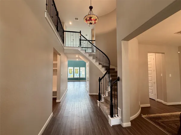 a view of a hallway with wooden floor and staircase