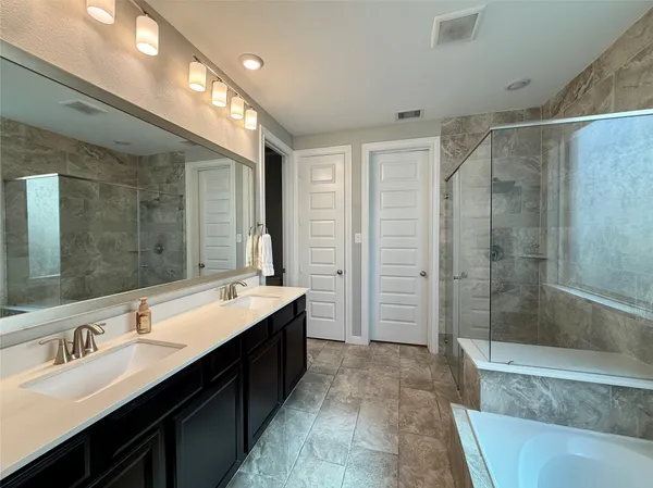 a bathroom with a double vanity sink mirror double and shower