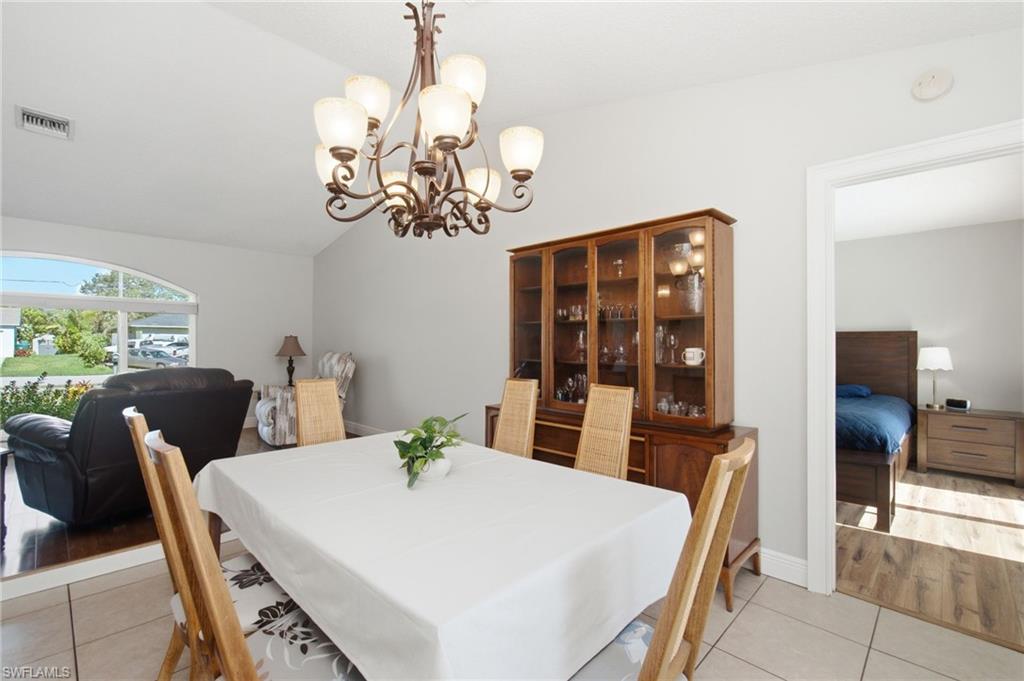 3022 47th Street Southwest Naples, FL 34116 - Photo 9 of 46 Dining area featuring a decorative chandelier and tile flooring