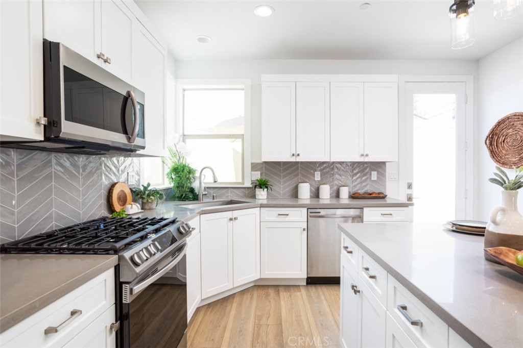 a kitchen with stainless steel appliances granite countertop a stove a sink and a microwave