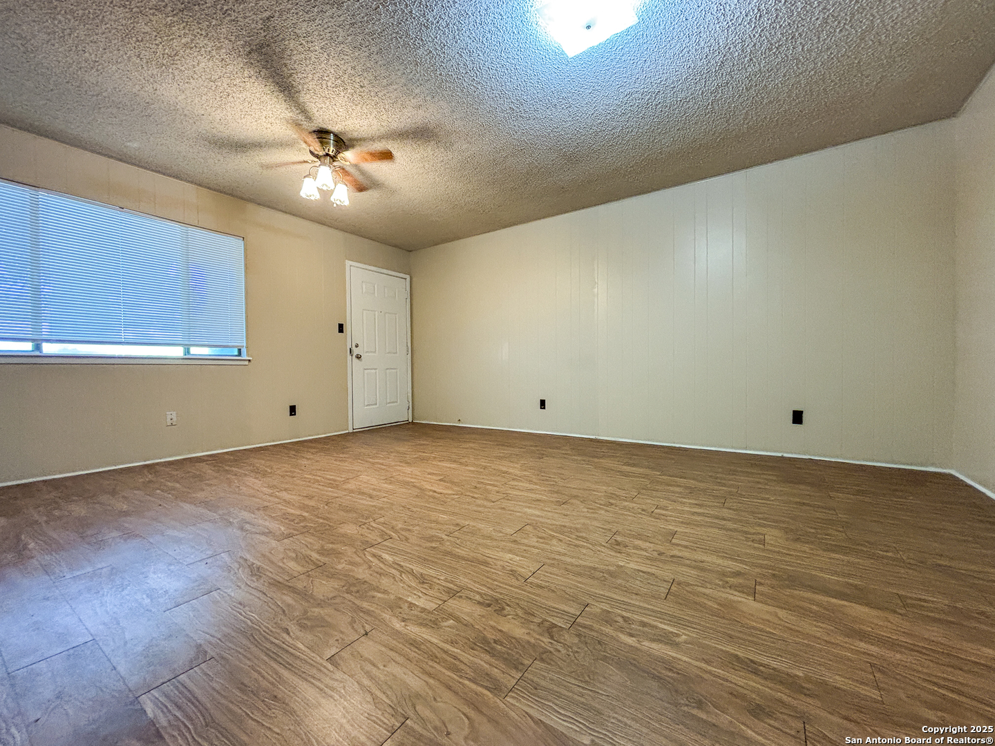 207 Redbud Lane, Unit B New Braunfels, TX 78130 - Photo 2 of 11 an empty room with wooden floor and fan