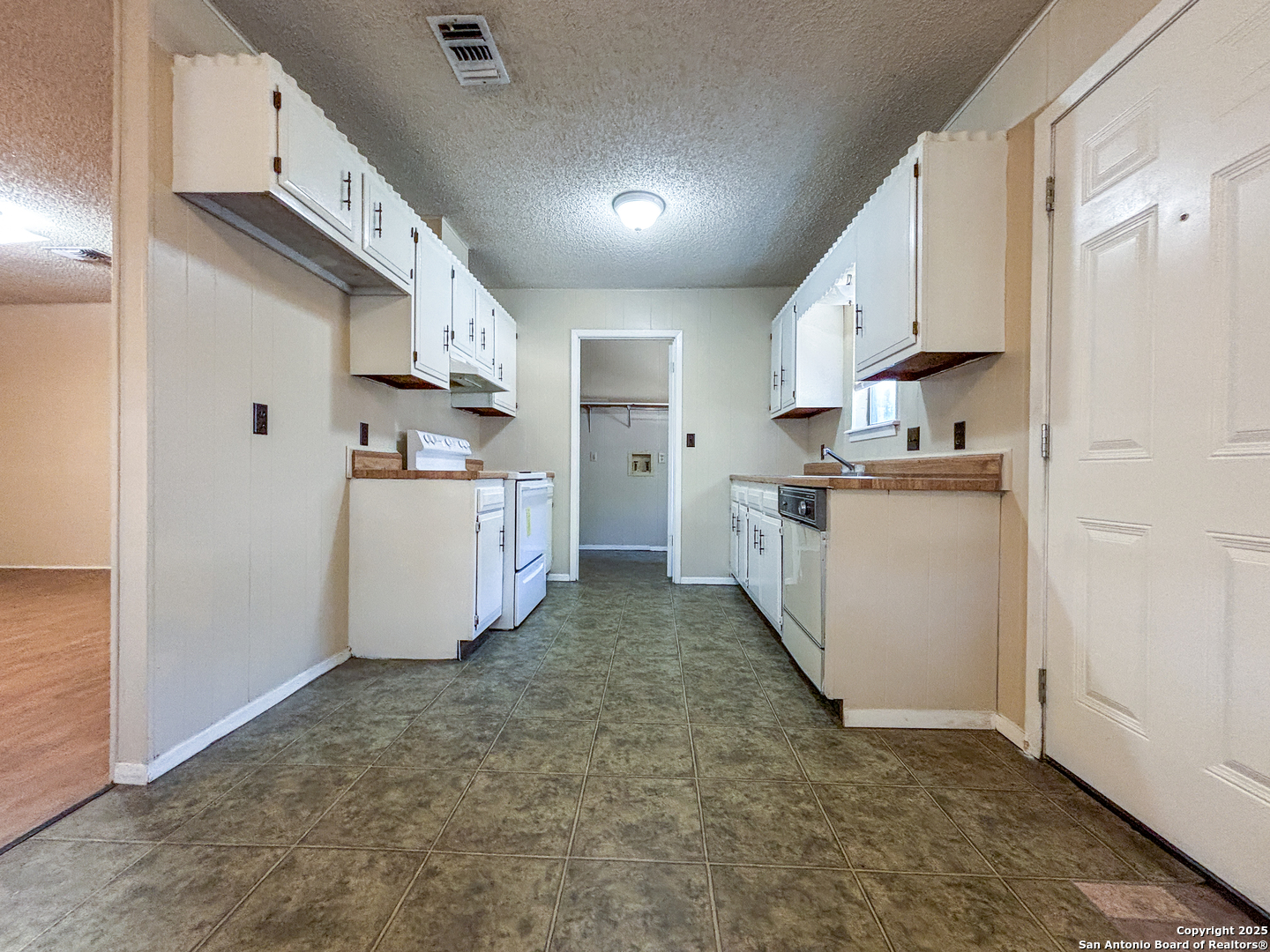 207 Redbud Lane, Unit B New Braunfels, TX 78130 - Photo 4 of 11 a kitchen with white cabinets and white appliances