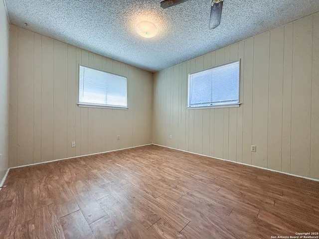 a view of empty room with wooden floor