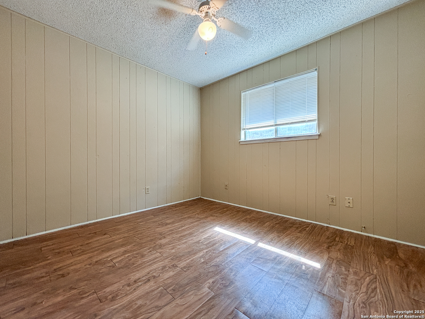 207 Redbud Lane, Unit B New Braunfels, TX 78130 - Photo 8 of 11 a view of an empty room with wooden floor and a chandelier fan