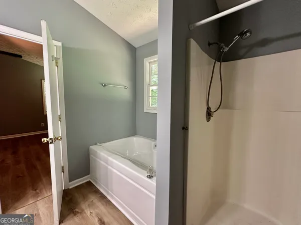 a bathroom with a tub shower and vanity