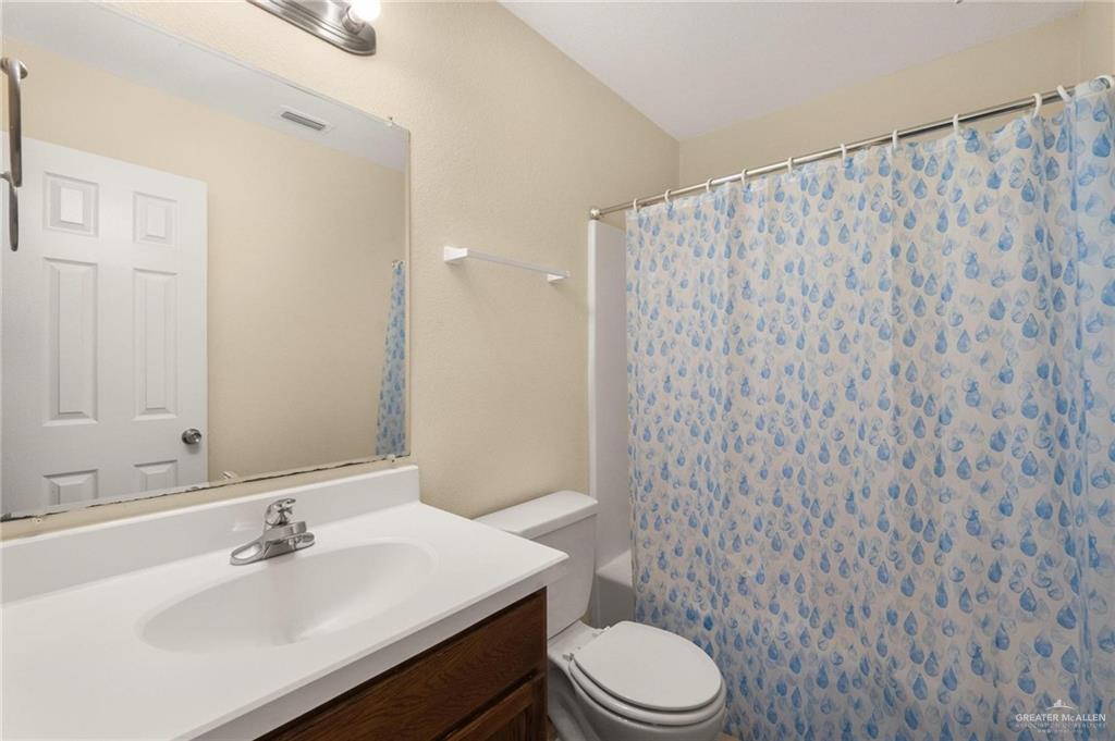 4716 Xanthisma Avenue McAllen, TX 78504 - Photo 11 of 17 a bathroom with a sink a toilet and shower curtain