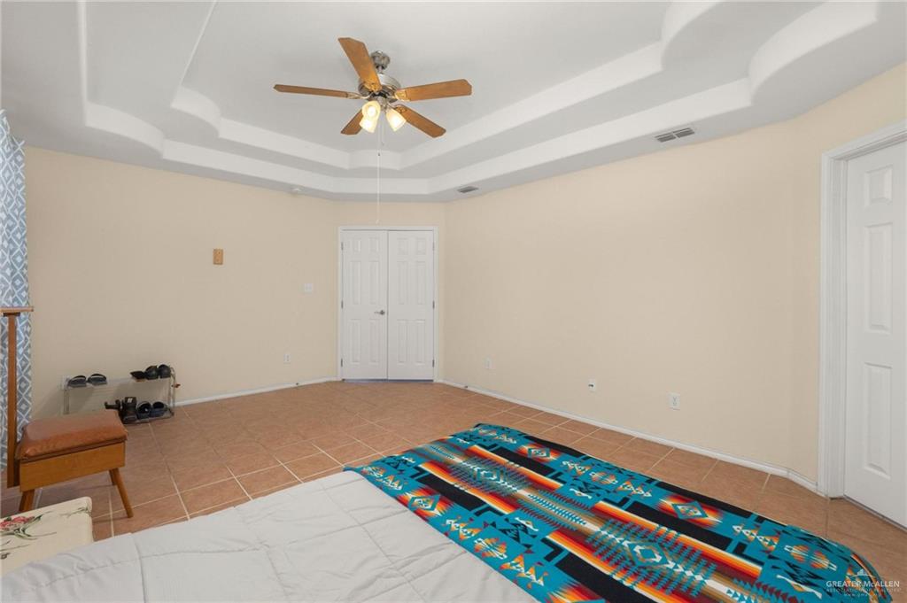 4716 Xanthisma Avenue McAllen, TX 78504 - Photo 7 of 17 a bedroom with a bed and a chandelier fan