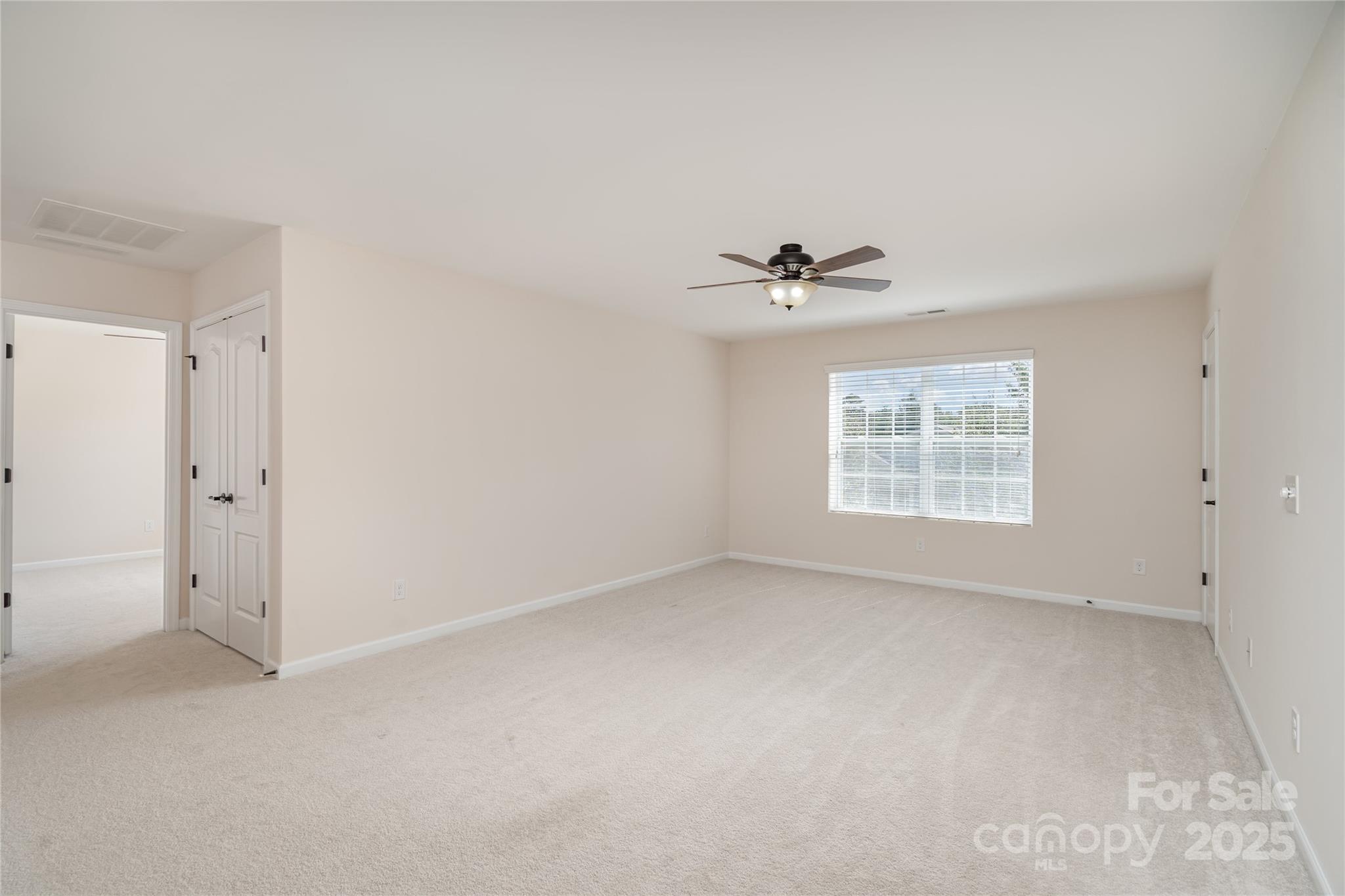 1528 Spring Blossom Trail Fort Mill, SC 29708 - Photo 18 of 26 an empty room with a window and a ceiling fan