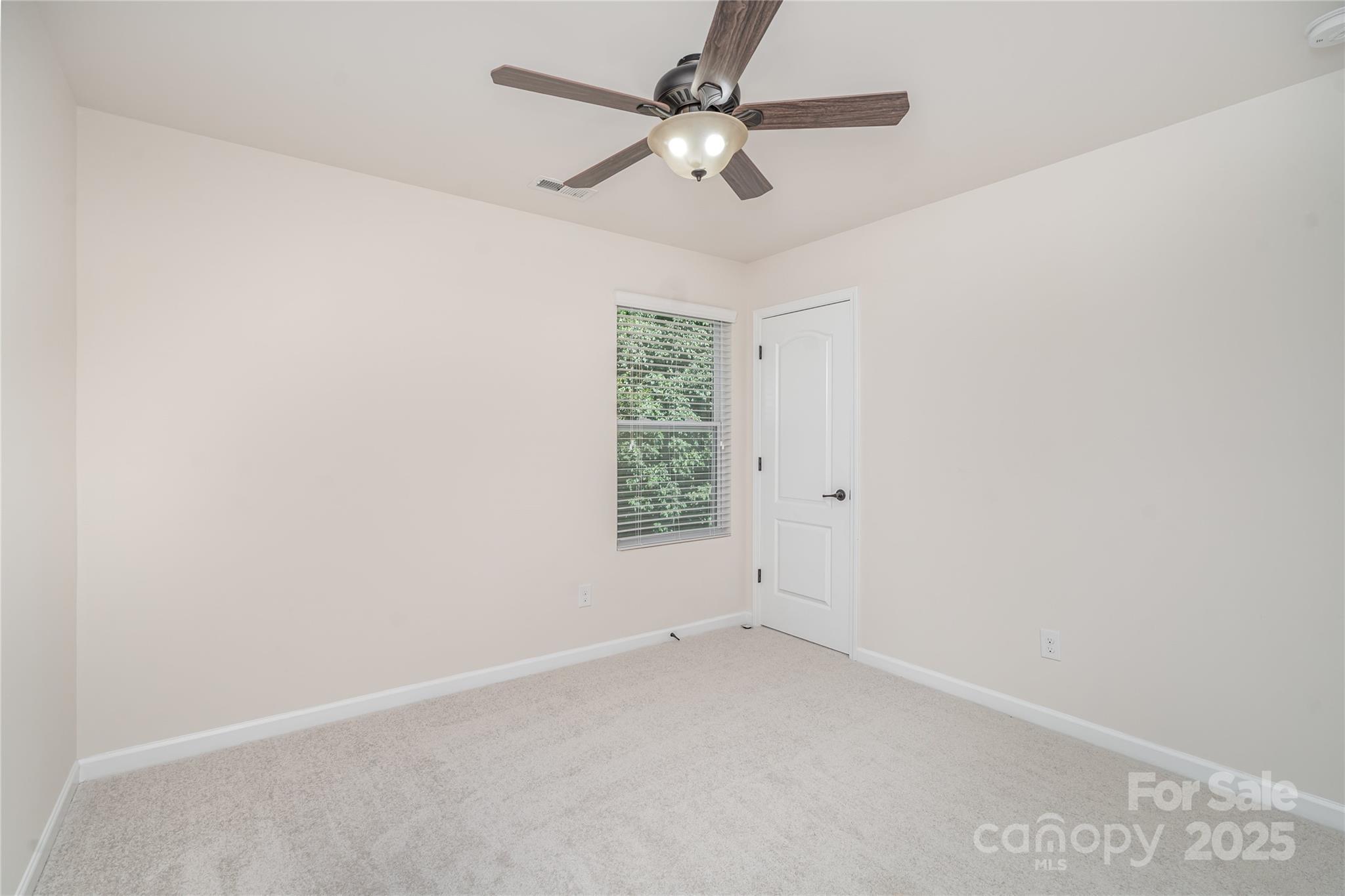 1528 Spring Blossom Trail Fort Mill, SC 29708 - Photo 20 of 26 an empty room with a window and a fan