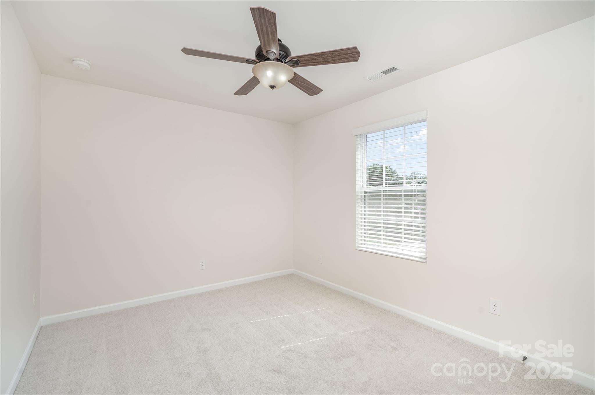 1528 Spring Blossom Trail Fort Mill, SC 29708 - Photo 22 of 26 an empty room with a window and a fan