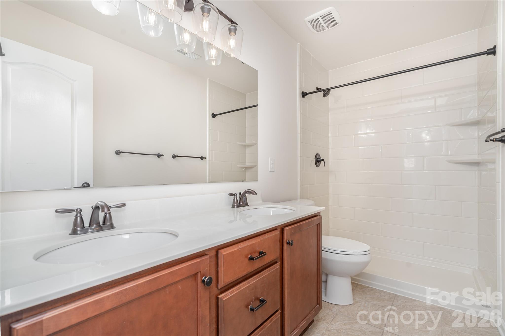 1528 Spring Blossom Trail Fort Mill, SC 29708 - Photo 25 of 31 a bathroom with a granite countertop sink a toilet and a shower