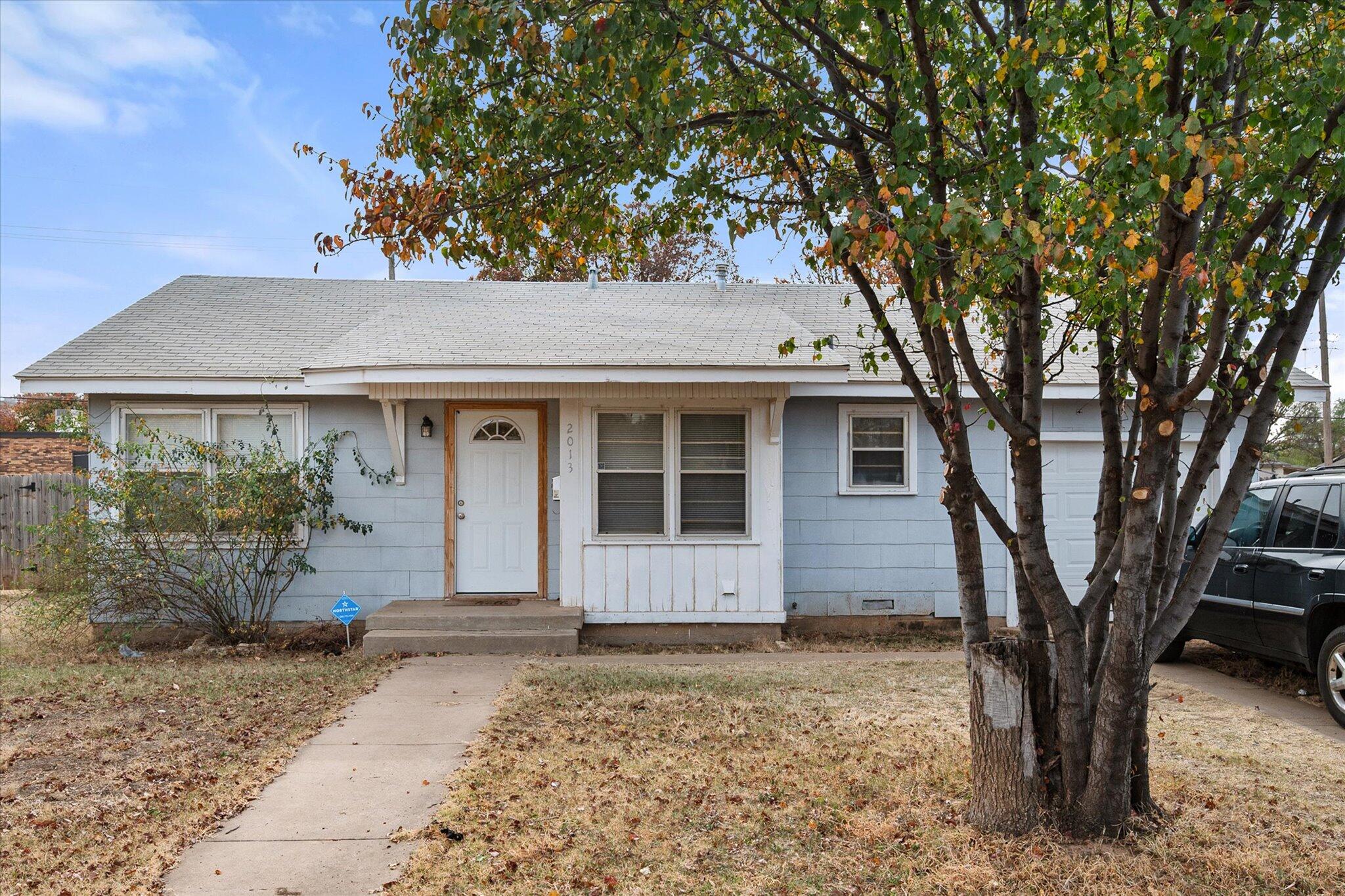 2013 58th Street Lubbock, TX 79412 - Photo 1 of 17 a front view of a house with a garden