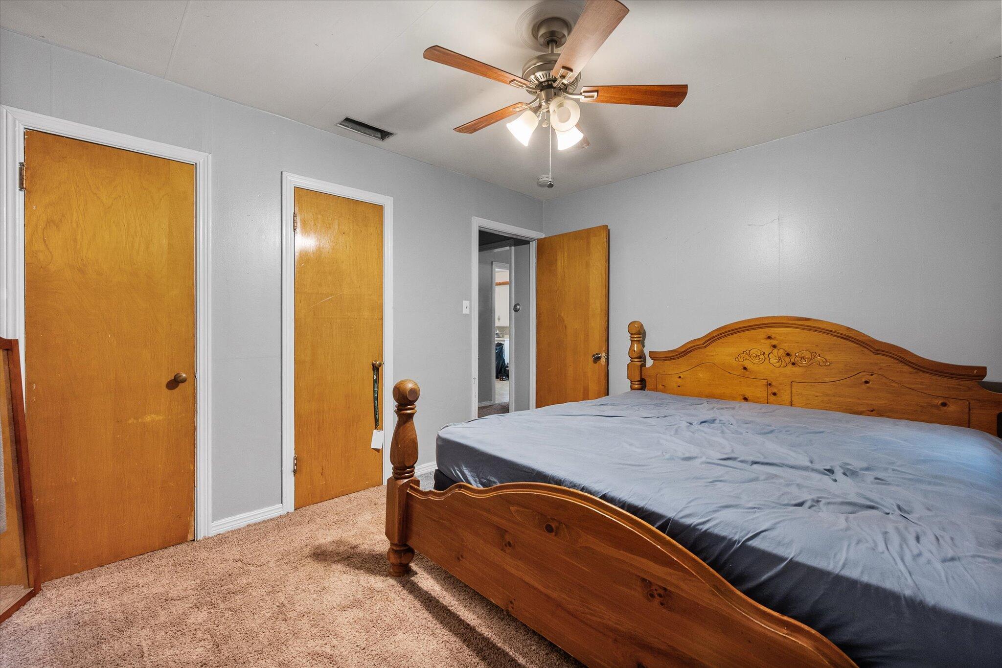 2013 58th Street Lubbock, TX 79412 - Photo 12 of 17 a bedroom with a bed and a chandelier