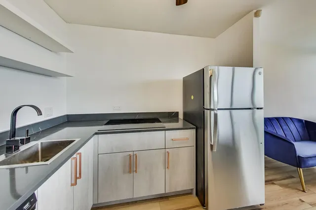 a kitchen with stainless steel appliances granite countertop a refrigerator a sink and a stove