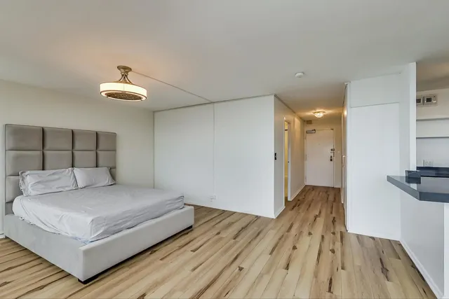 a bedroom with a bed and a chandelier