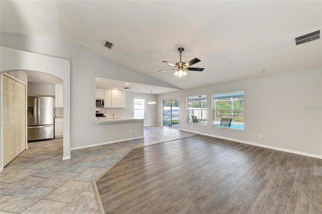 11611 Summit Rock Court Parrish, FL 34219 - Photo 20 of 54 a view of an empty room with wooden floor and a kitchen