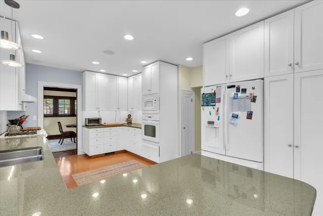 a large white kitchen with lots of counter space a sink and stainless steel appliances