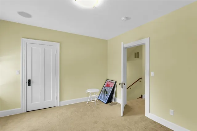 a spacious bedroom with a bed and wooden floor