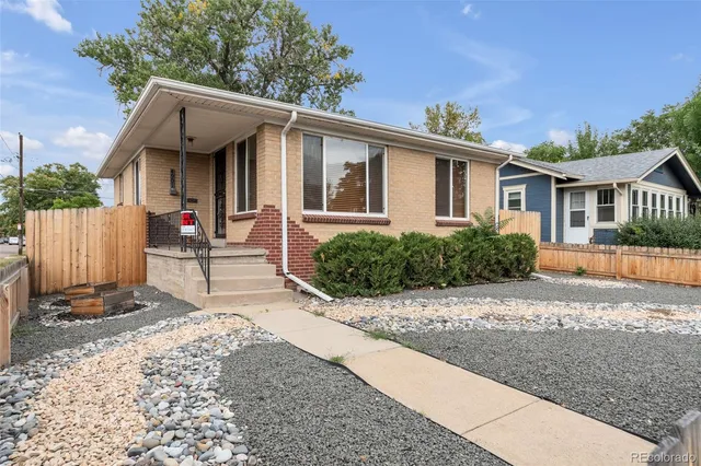 a view of a house with a yard and large tree and wooden fence