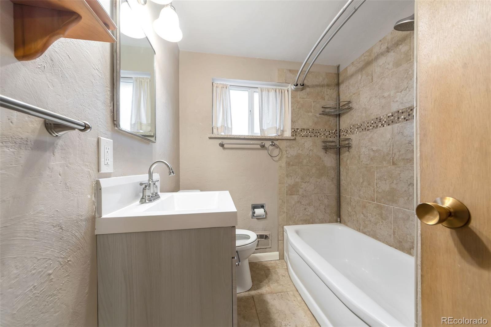 4901 Grove Street Denver, CO 80221 - Photo 11 of 25 a bathroom with a sink a toilet and shower