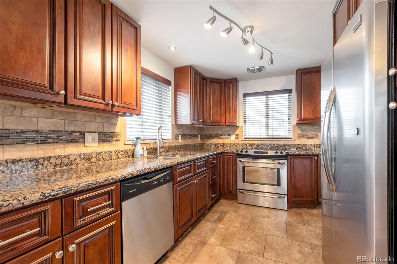 4901 Grove Street Denver, CO 80221 - Photo 4 of 25 a large kitchen with stainless steel appliances granite countertop a stove sink and cabinets