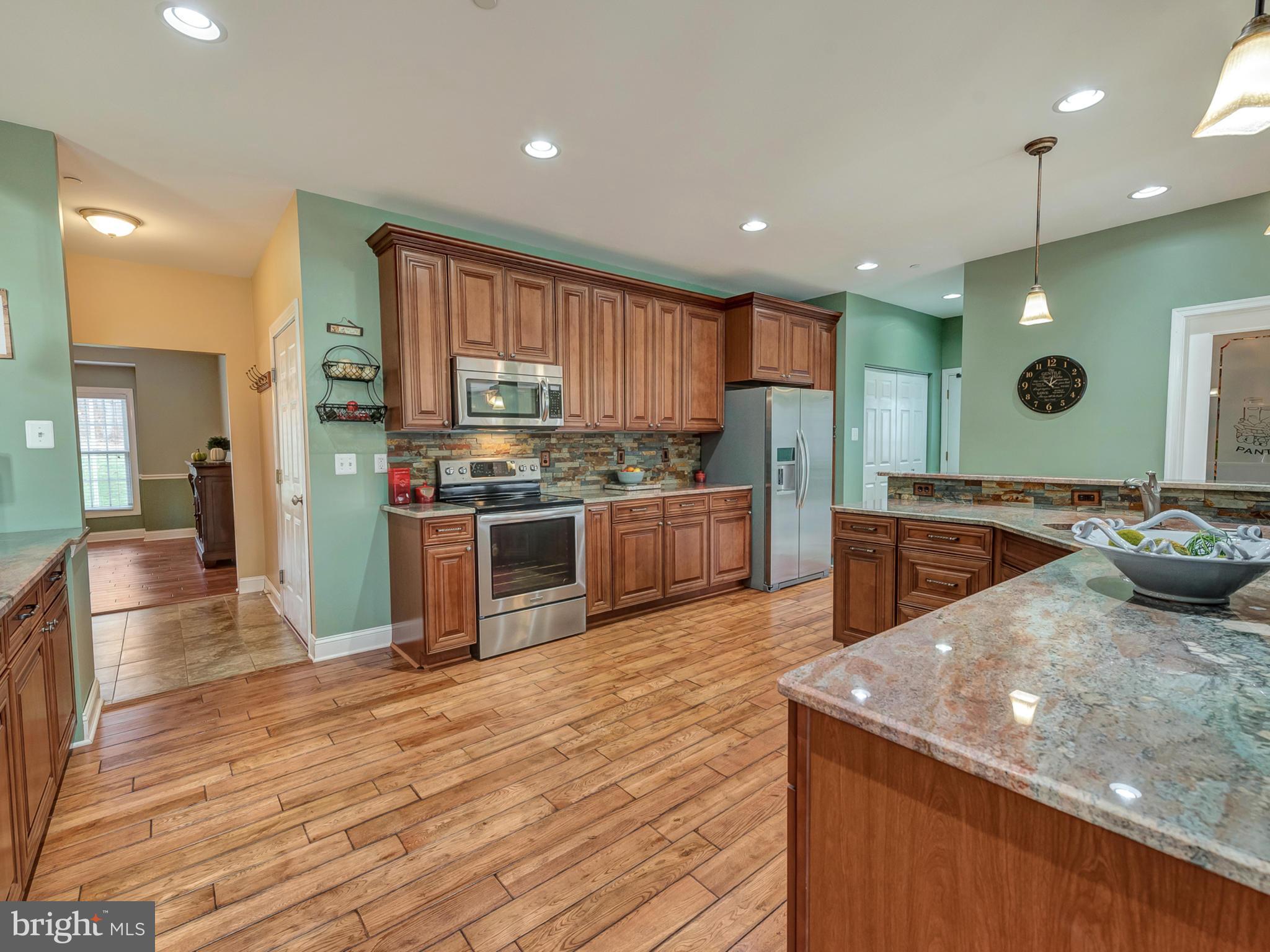 4947 Old Swimming Pool Road Frederick, MD 21703 - Photo 18 of 72 a large kitchen with stainless steel appliances kitchen island granite countertop a large counter top and a stove